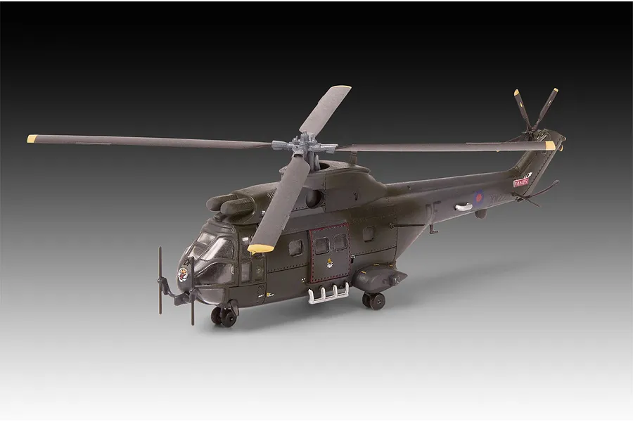A completed 1/144 scale plastic model of a Westland Puma HC.1 helicopter in dark olive green military livery, shown against a gradient background.