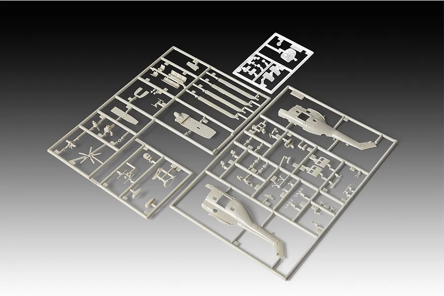 Unassembled plastic model kit sprues for a 1/144 scale Westland Puma helicopter, featuring grey plastic parts on frames against a gradient background.