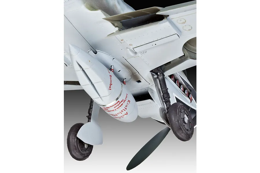 Close-up of the underside of a 1/32 scale Messerschmitt Bf109G-10 model aircraft showing the landing gear and a drop tank with German warning text.