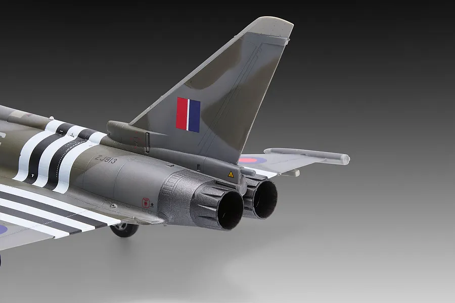 Close-up of the rear section of a 1/48 scale Eurofighter Typhoon model, showing the tail fin, twin engine nozzles, and D-Day invasion stripes.