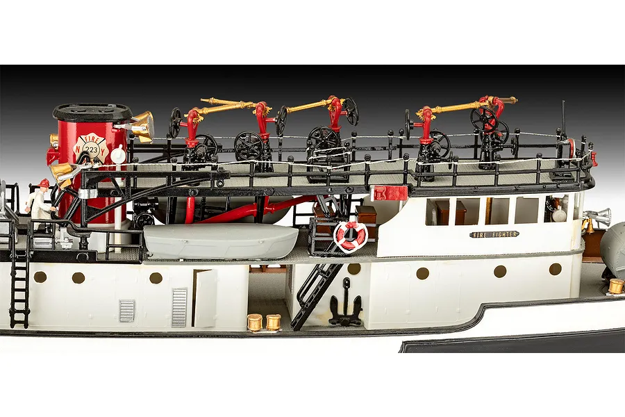 Close-up of a detailed 1/87 scale plastic model of a fireboat, showing deck equipment, water cannons, and a red funnel.
