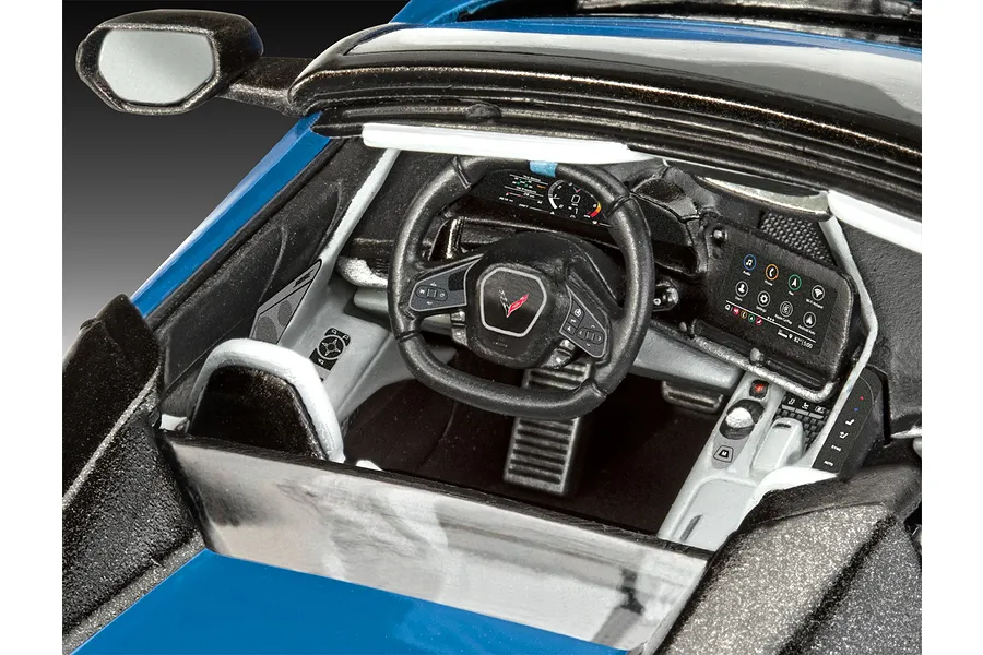 Close-up view of the detailed interior of a 1/25 scale Revell Corvette C8 Cabriolet model car, showing the dashboard, steering wheel, and center console.