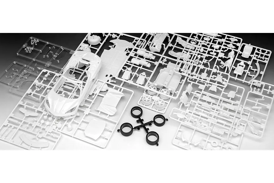Unassembled plastic model kit parts for a Revell 1/25 Corvette C8 Cabriolet, including white sprues, clear parts, and black rubber tires.
