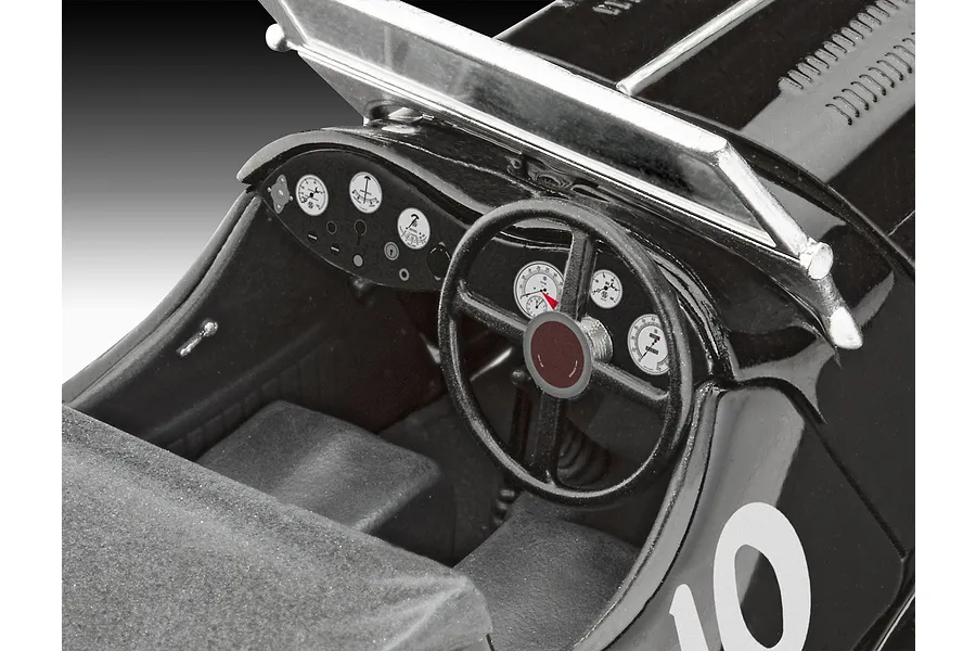 Close-up of the detailed interior cockpit of a 1/32 scale Jaguar SS 100 plastic model car, showing the steering wheel, dashboard gauges, and seats.