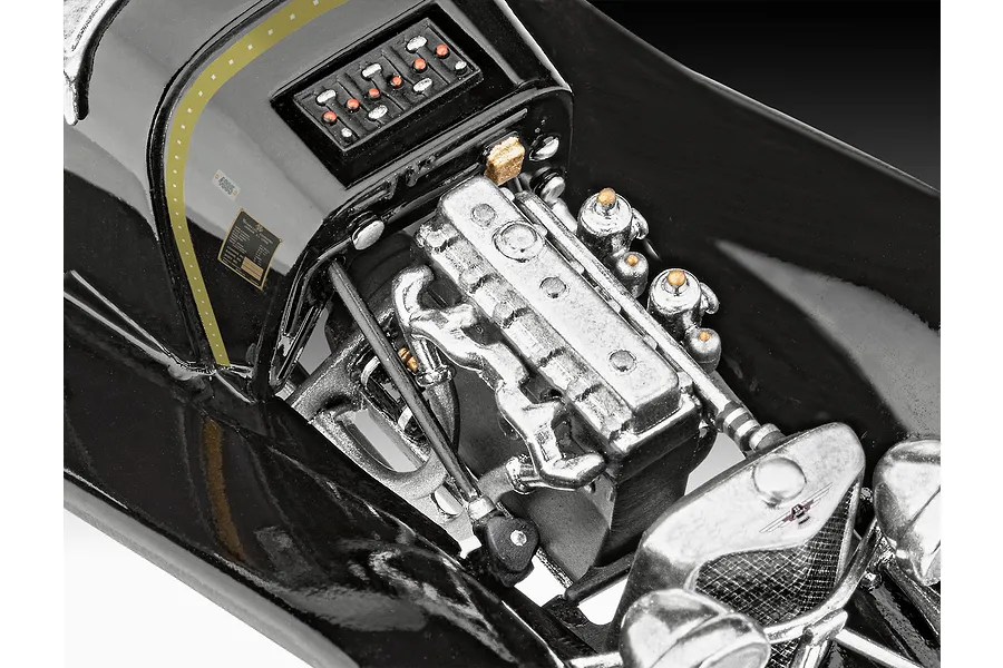 Close-up of the detailed engine bay of a Revell 1/32 scale Jaguar SS 100 model car, showing the silver engine block and black chassis.