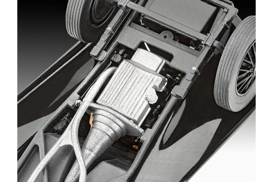 Close-up view of the underside of a 1/32 scale Jaguar SS 100 model car, showing the engine, transmission, and chassis details.