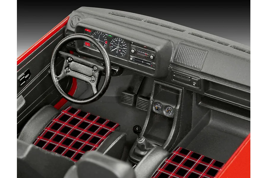 Detailed interior view of a 1/24 scale VW Golf GTi model, featuring a black dashboard, steering wheel, and iconic red and black tartan seat upholstery.