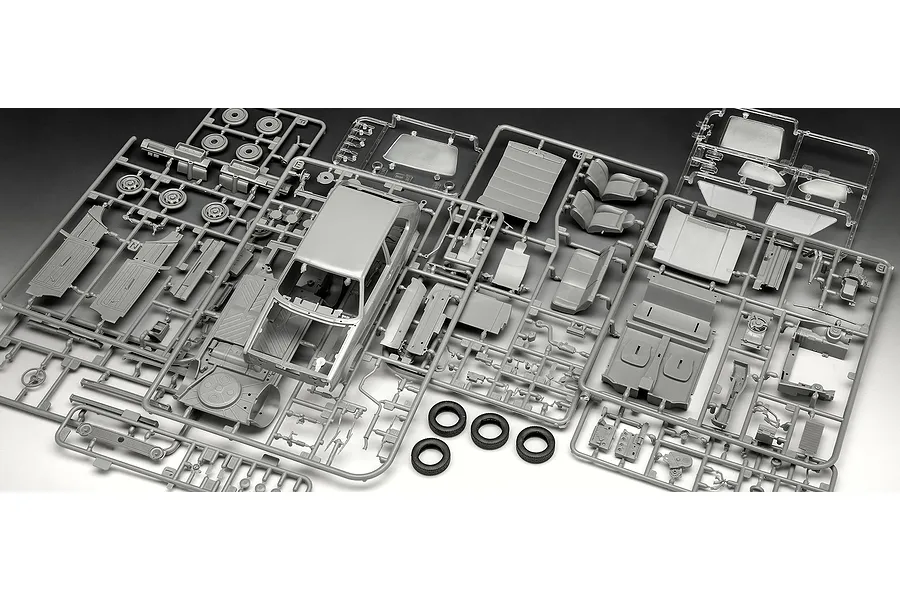 Grey plastic model kit sprues for a 1/24 scale VW Golf GTi, including car body, interior parts, and rubber tires on a dark background.