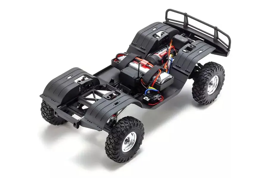 High-angle view of a Kyosho RC rock crawler chassis without the body shell, showing the frame, wheels, motor, and electronics on a white background.