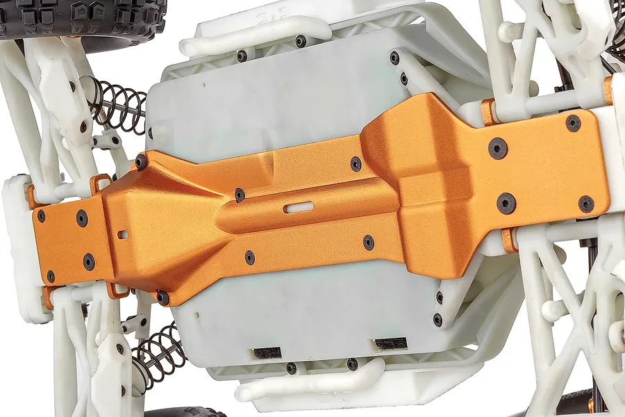 Close-up view of the underside of a Team Associated Rival MT10 RC monster truck chassis featuring a metallic orange aluminum skid plate.