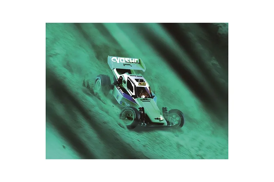 Kyosho Tomahawk '85 WC Worlds Spec RC buggy driving on a dirt track with a green-tinted motion blur effect.