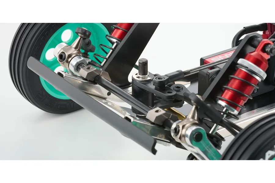 Close-up of the front suspension and steering assembly of a Kyosho Tomahawk RC buggy, featuring red shocks and teal wheels.