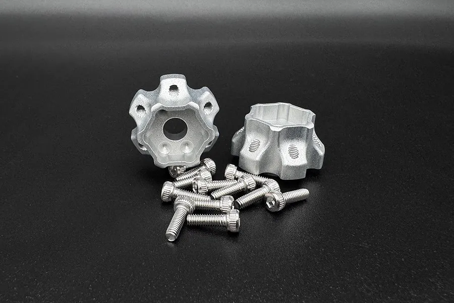 Two silver aluminium wheel hex hubs with a DOT design and a set of matching metal socket head screws on a black background.