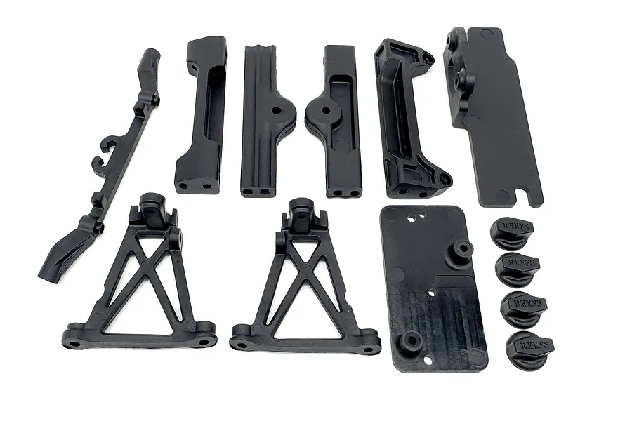 A set of black plastic RC chassis braces and body mounts from Reefs RC, including various structural components and four branded body post knobs.