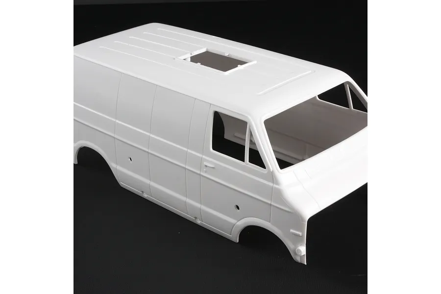 An unpainted white plastic body shell for a 1/12 scale Tamiya Lunch Box RC van, viewed from a high angle against a black background.