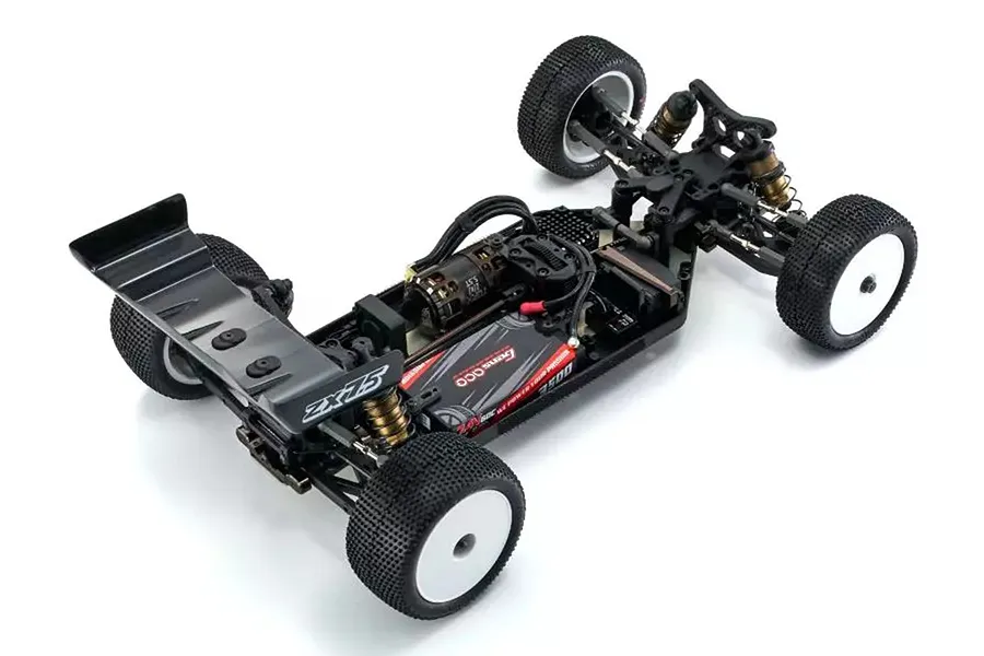 High-angle view of a Kyosho Lazer ZX7.5 1/10 scale 4WD electric RC buggy chassis, fully assembled with motor, battery, and white wheels.