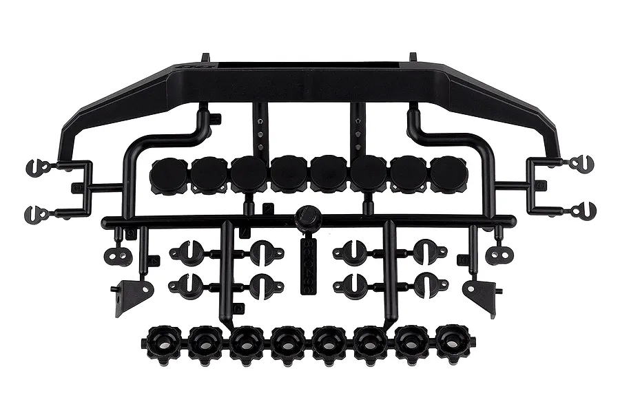 A black plastic parts tree containing a front bumper, light buckets, and various mounting accessories for an RC vehicle.