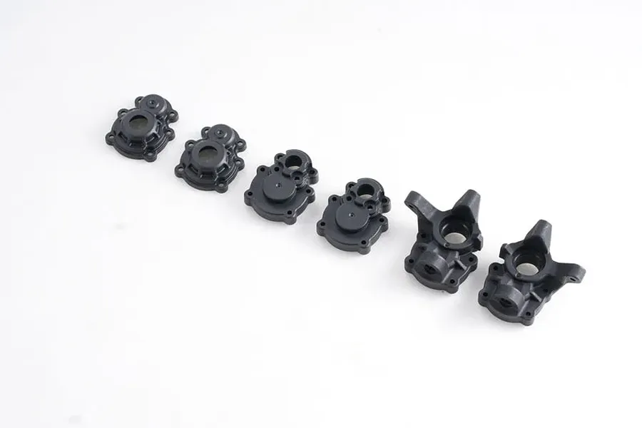 A set of six black plastic portal axle housing components for an RC vehicle, arranged in a line on a white background.