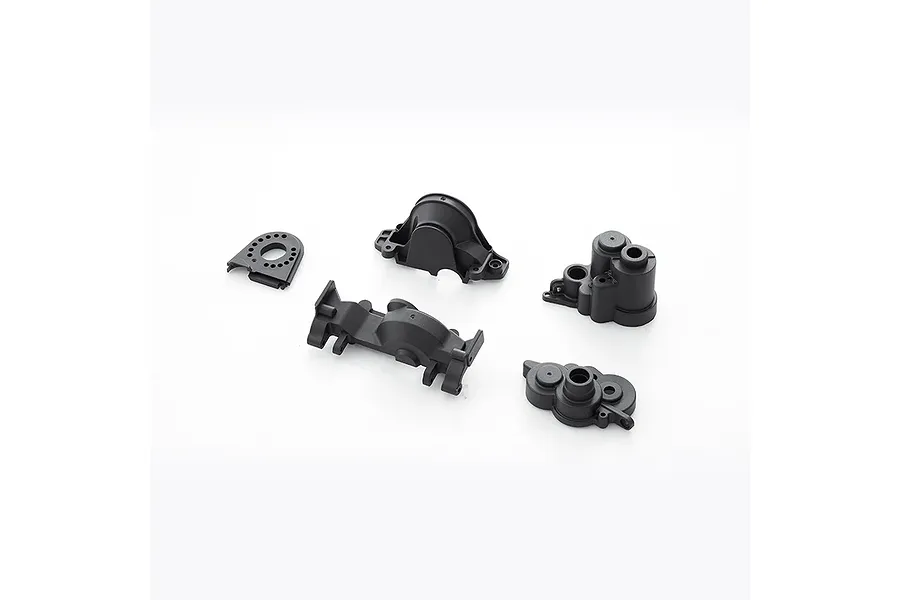 A set of four black plastic FMS V2 gearbox case components arranged on a white background.