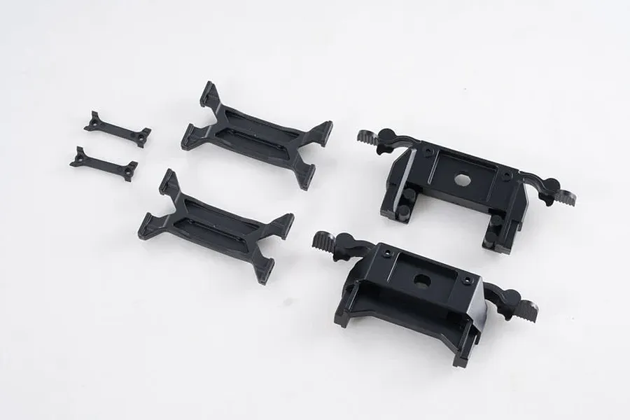 A set of black plastic RC chassis girder mounts and brackets on a white background.