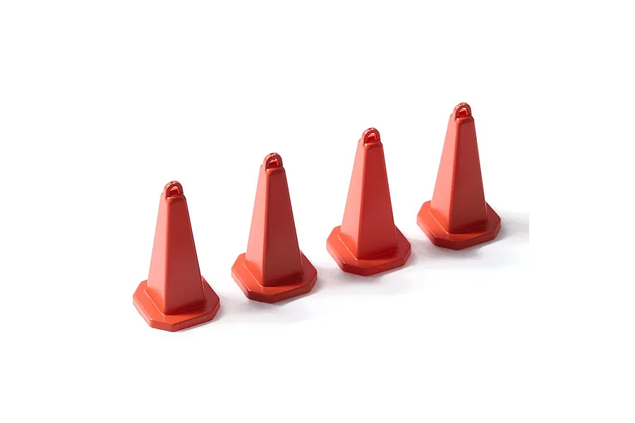 Four small red plastic traffic cones arranged in a row against a white background.