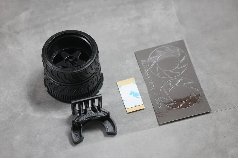 Pandora RC steering wheel accessory kit for Futaba 7PX/10PX transmitters, including a wheel, brake caliper part, adhesive strip, and decal sheet.