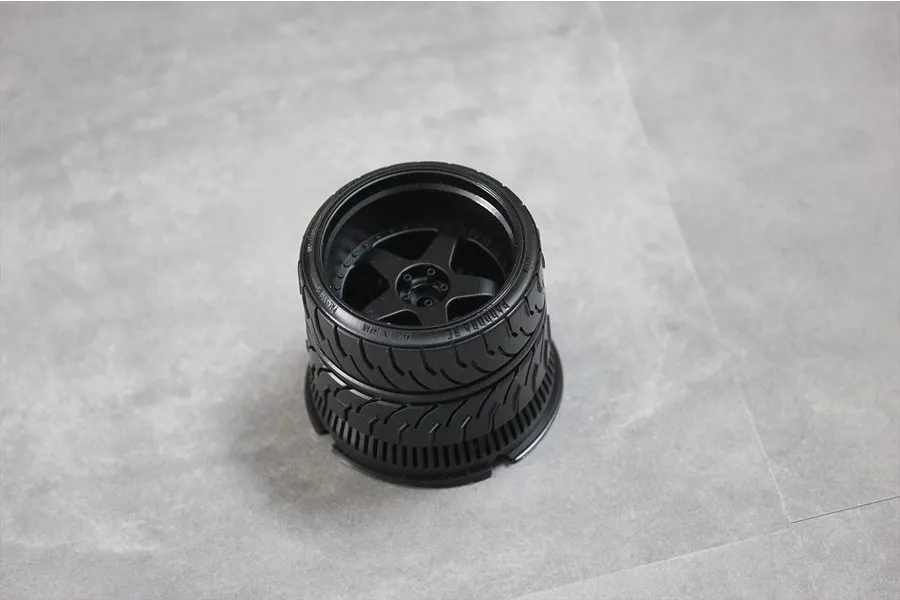 A black Pandora RC transmitter steering wheel accessory for Sanwa radios, viewed from above on a grey surface.