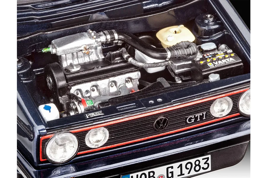 Close-up of a detailed 1/24 scale model car engine bay for a 1983 VW Golf GTI, showing the engine, Varta battery, and front grille.