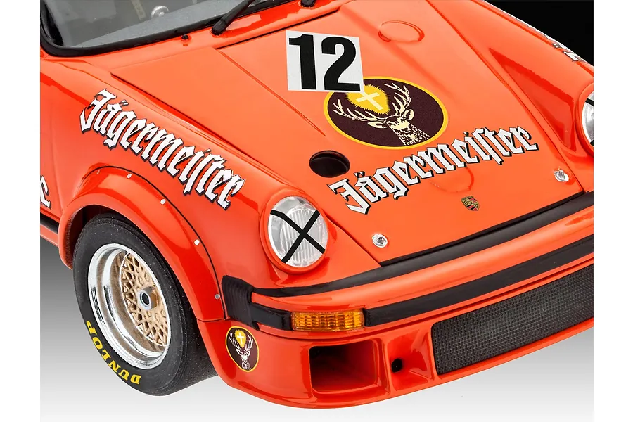 Close-up of a 1/24 scale Porsche 934 RSR Jägermeister model car showing the front hood, headlight, and wheel with racing decals.