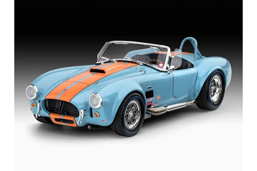 A completed 1/24 scale model of a light blue Shelby Cobra 427 with orange racing stripes, chrome wheels, and side-exit exhaust pipes.