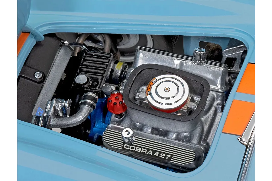 Close-up of the detailed engine bay of a 1/24 scale Revell Shelby Cobra 427 model car, showing the engine block, air cleaner, and valve covers.