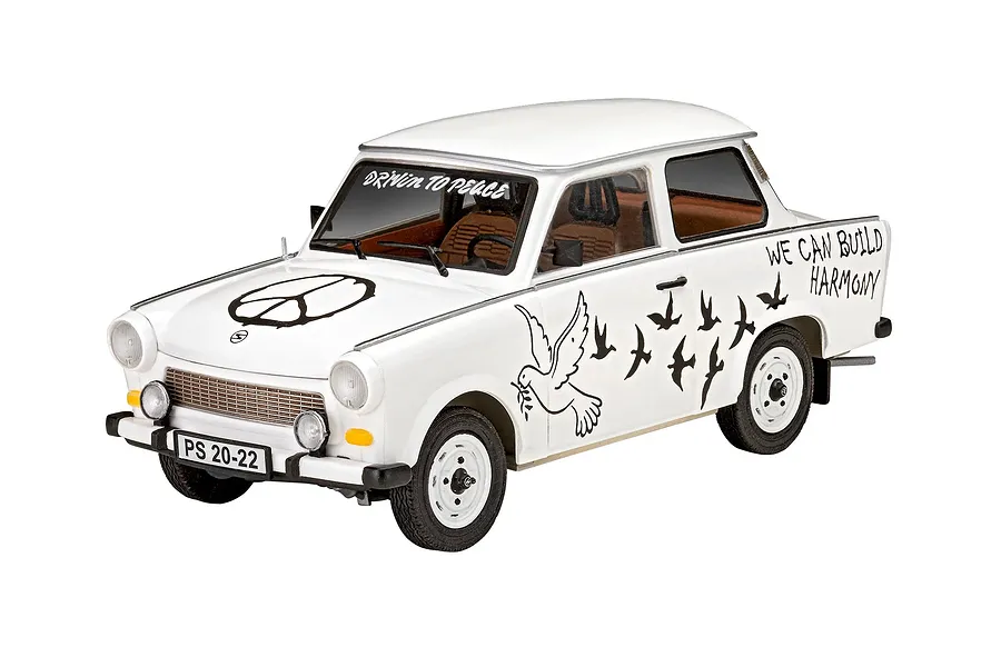 A 1/24 scale model of a white Trabant 601S car with peace-themed decals including a peace sign, doves, and the text 'DRIVIN TO PEACE' and 'WE CAN BUILD HARMONY'.