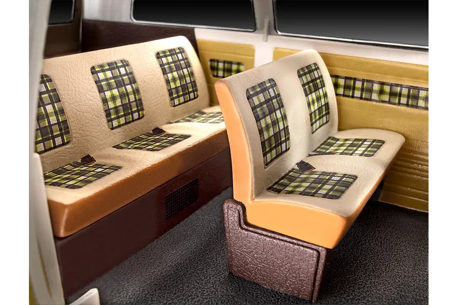 Interior view of a Revell 1/24 scale VW T3 model bus showing beige and brown bench seats with green and black plaid fabric patterns.