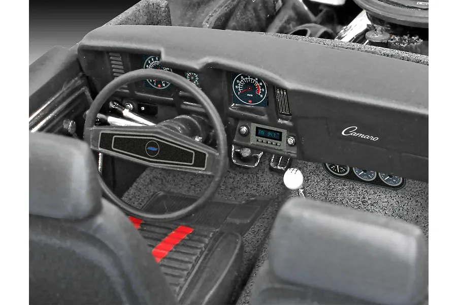 Close-up of the detailed interior of a 1/25 scale 1969 Chevy Camaro model car, showing the dashboard, steering wheel, and front seats.