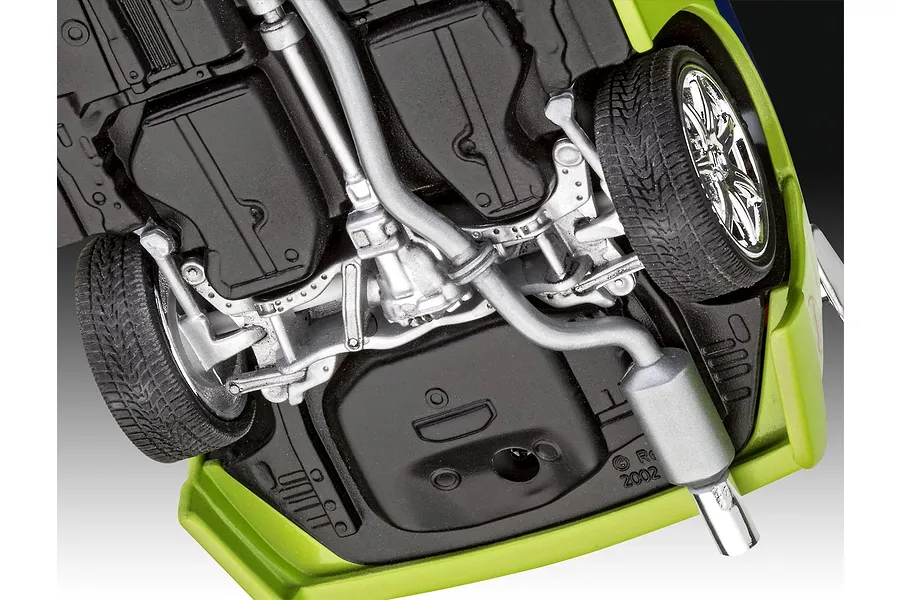 Underside view of a 1/25 scale model car showing the chassis, exhaust system, and suspension details.