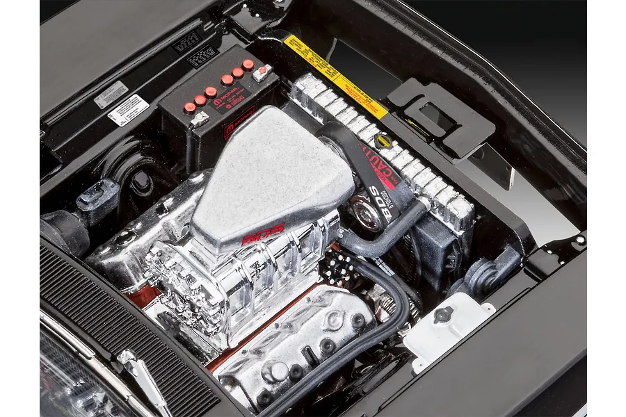 Close-up of the detailed engine bay of a 1/25 scale Revell 1970 Dodge Charger model kit, featuring a chrome supercharger and Mopar battery.