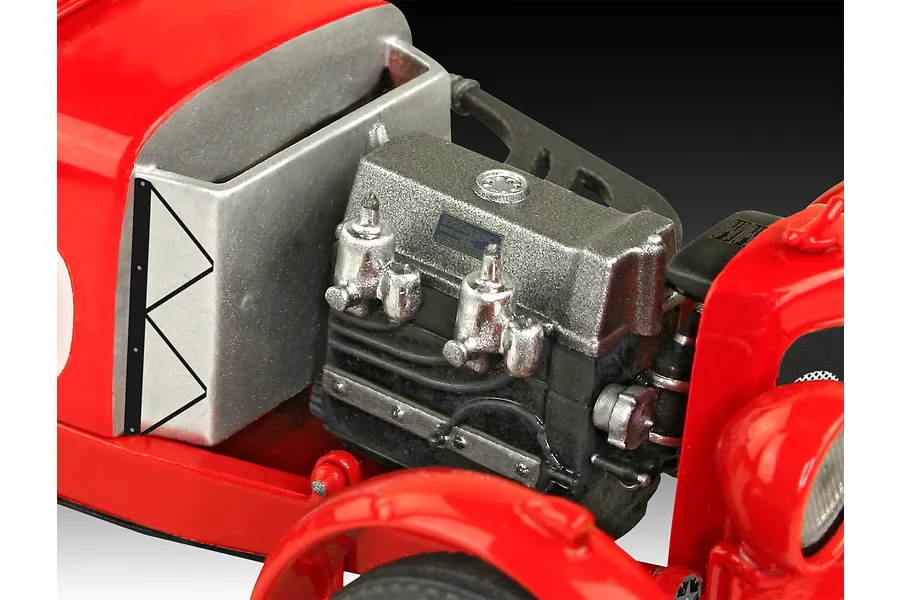 Close-up of the engine bay of a red Aston Martin Ulster model car, showing the detailed engine block and silver firewall.
