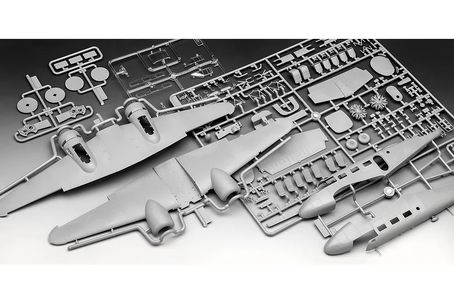 Grey plastic model aircraft kit sprues for a Beechcraft Model 18, including wings, fuselage halves, and engine parts on a gradient background.