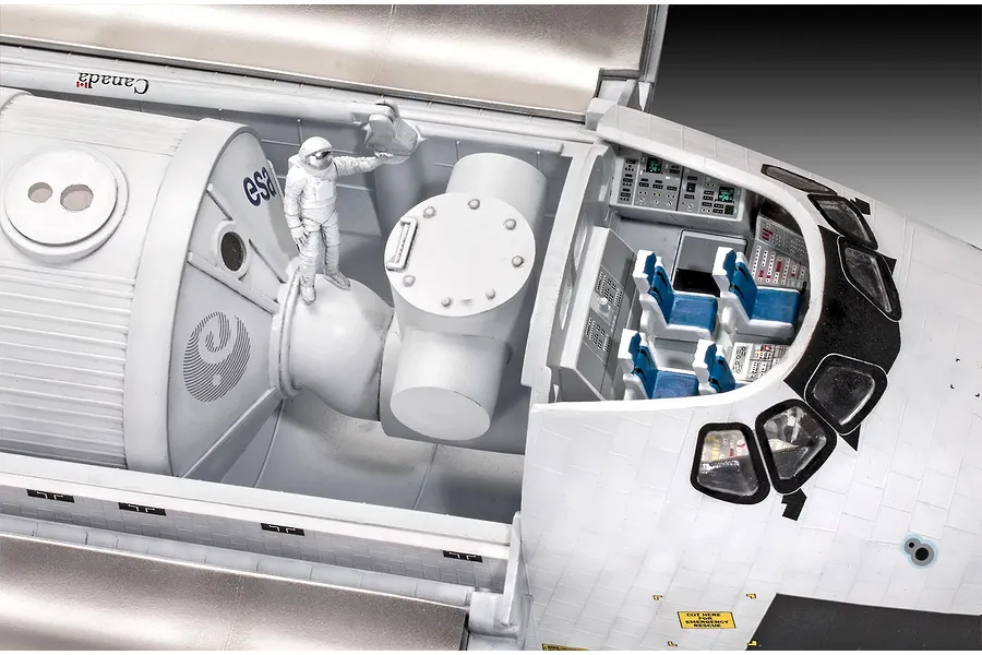 Close-up of the interior cargo bay and cockpit of a 1/72 scale Revell Space Shuttle model, showing an astronaut figure and detailed control panels.