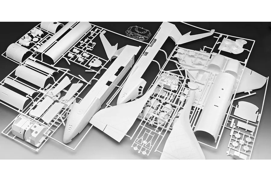 White plastic model kit sprues for a Space Shuttle model, showing various fuselage, wing, and engine components attached to frames.