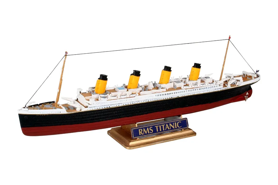 A fully assembled 1/1200 scale plastic model of the RMS Titanic, featuring yellow funnels, a black and red hull, and a gold-coloured display stand.