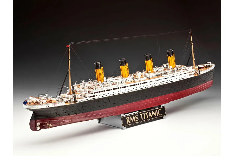 A fully assembled 1/400 scale plastic model of the RMS Titanic, featuring four yellow funnels, black and white hull, and a display stand with a nameplate.