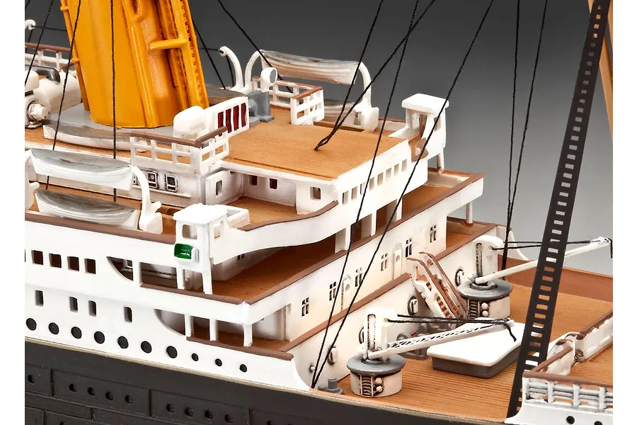 Close-up of the deck details on a Revell 1/400 scale RMS Titanic model, showing white railings, wooden-look decking, lifeboats, and rigging.