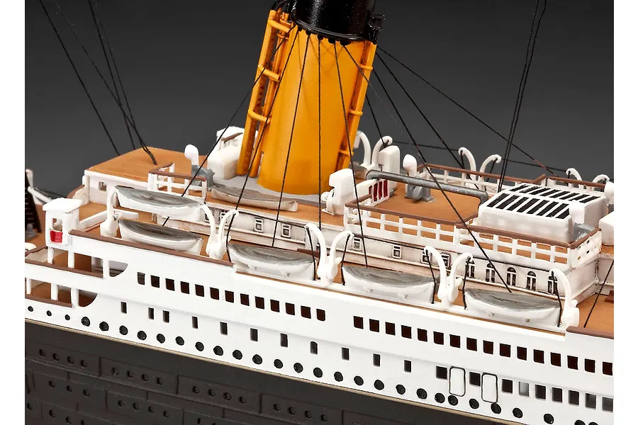 Close-up of a detailed Revell 1/400 scale RMS Titanic model showing the deck, lifeboats, and a yellow funnel with rigging.
