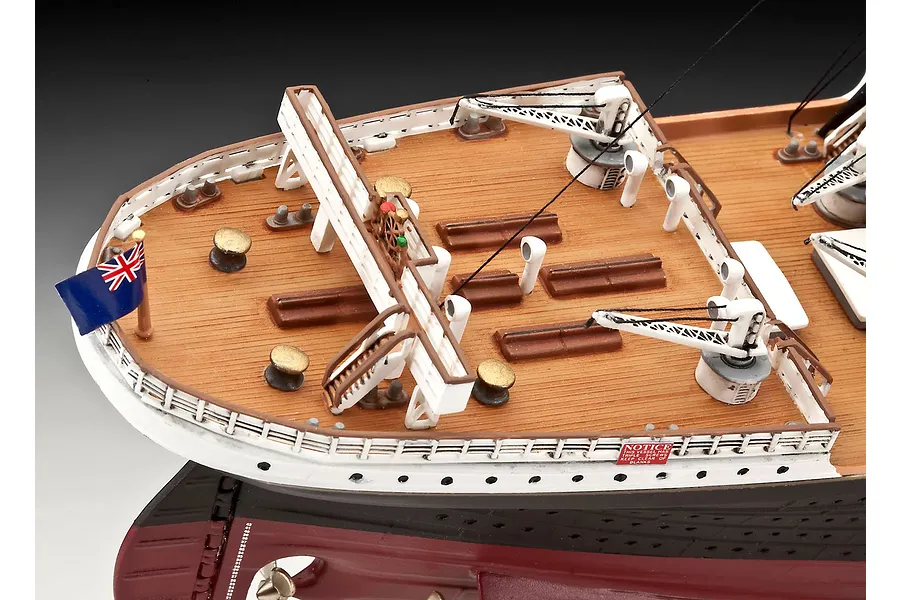 High-angle view of the stern deck of a Revell 1/400 scale RMS Titanic model, showing the wooden-textured deck, white railings, cranes, and a British flag.