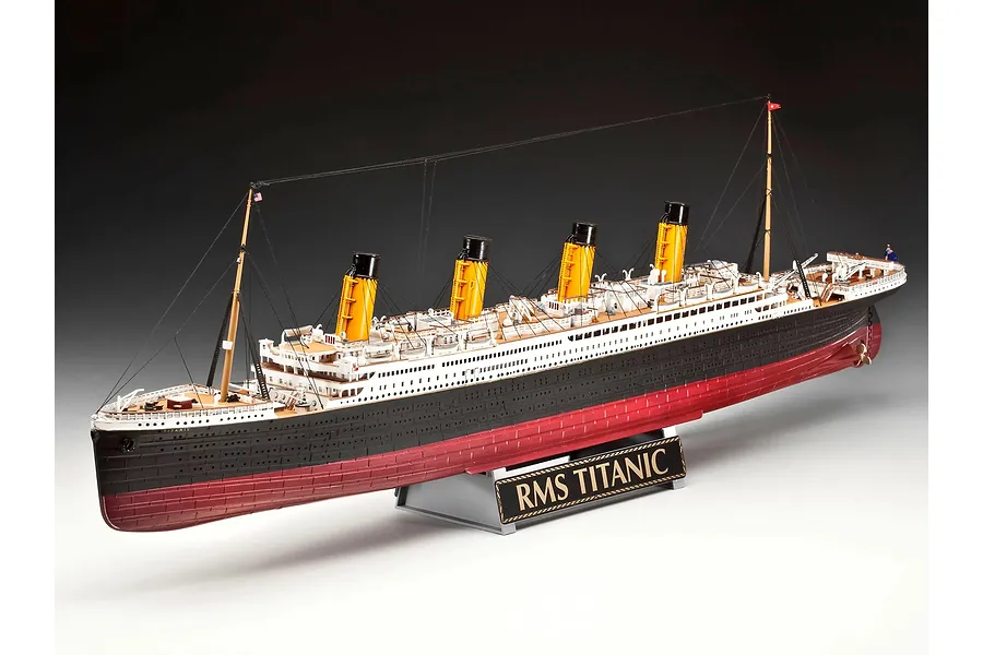 A fully assembled 1/400 scale plastic model of the RMS Titanic, featuring four yellow funnels, black and white hull, and a display stand with a nameplate.