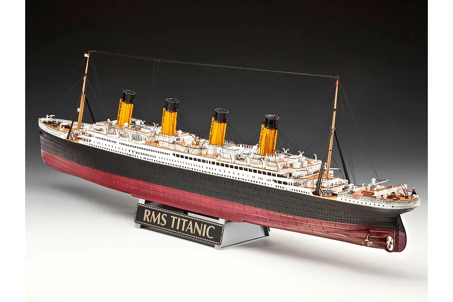 A fully assembled 1/400 scale plastic model of the RMS Titanic, featuring four yellow funnels, black and white hull, and a display stand with a nameplate.