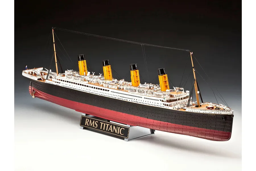 A fully assembled 1/400 scale plastic model of the RMS Titanic, featuring black hull, red bottom, and four yellow funnels, displayed on a stand.