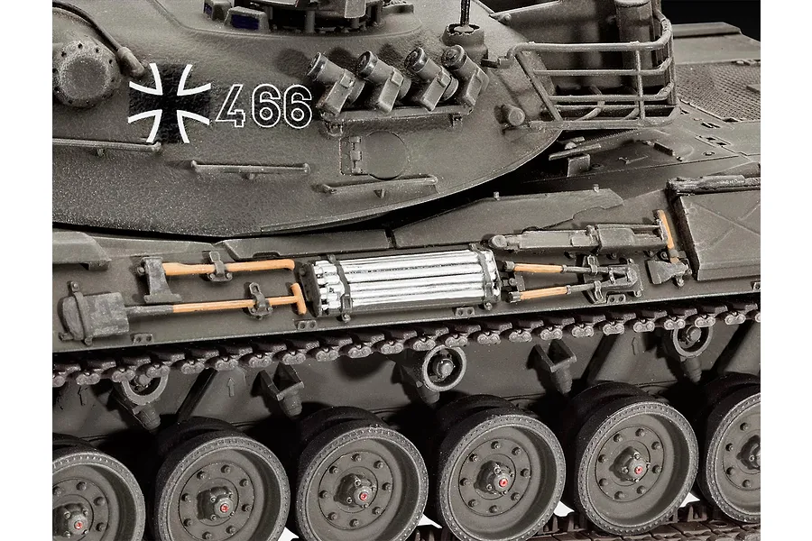 Close-up of a 1/35 scale Leopard 1 tank model showing the side hull, turret, road wheels, and attached tools.