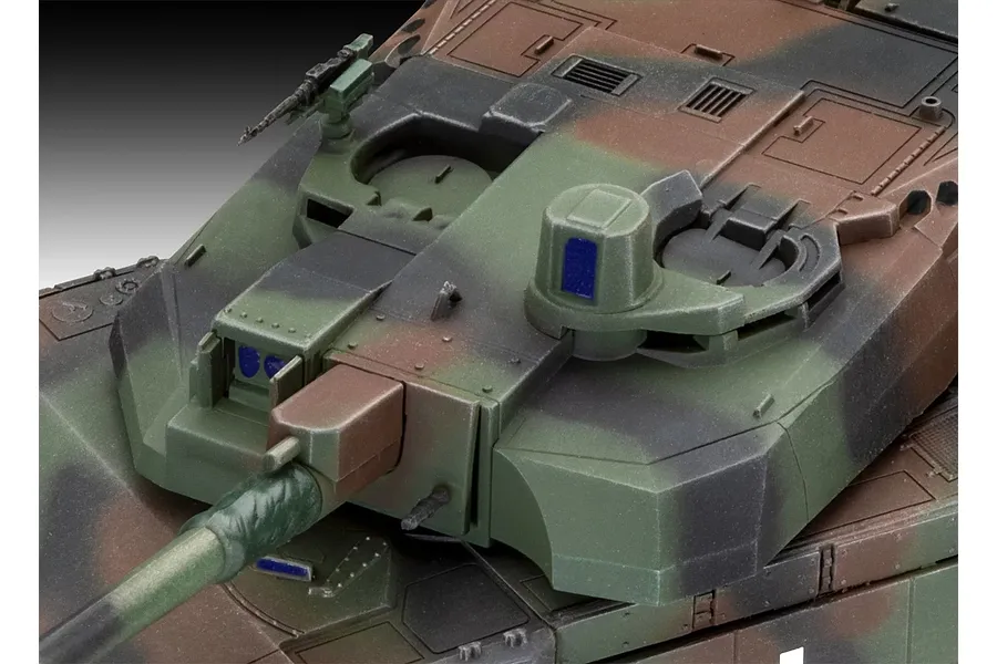 Close-up of the turret and main gun of a painted 1/72 scale Leclerc tank model featuring a camouflage pattern of green, brown, and black.